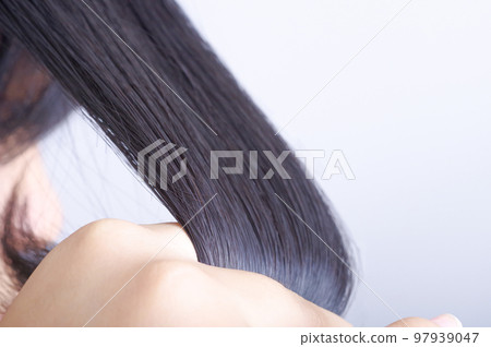 A woman touching her hair A woman touching her hair 97939047