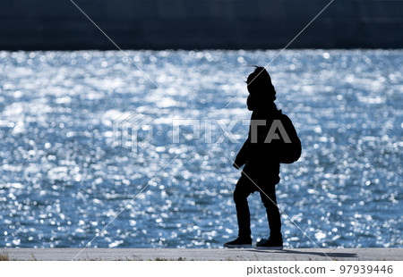 silhouette of people walking on the beach silhouette of people walking on the beach 97939446