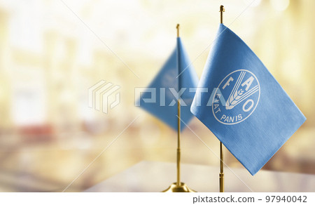 Small flags of the Food and agriculture organization on an abstract blurry background Small flags of the Food and agriculture organization on an abstract blurry background 97940042