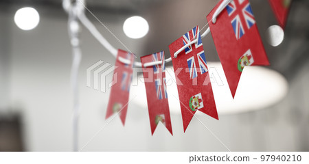 A garland of Bermuda national flags on an abstract blurred background 97940210