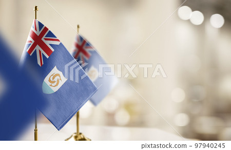 Small flags of the Anguilla on an abstract blurry background 97940245