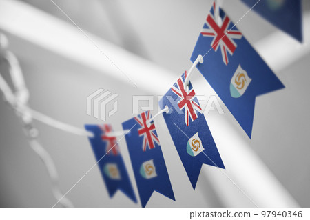 A garland of Anguilla national flags on an abstract blurred background 97940346