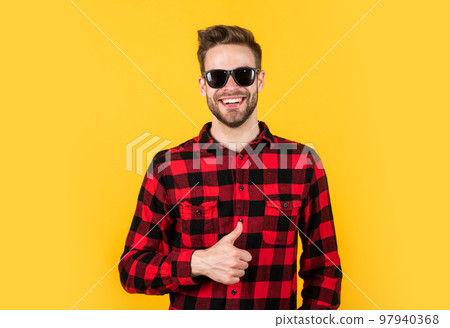 young handsome man in checkered shirt and sunglasses has bristle on face, vacation young handsome man in checkered shirt and sunglasses has bristle on face, vacation 97940368