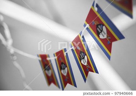 A garland of Swaziland national flags on an abstract blurred background 97940666
