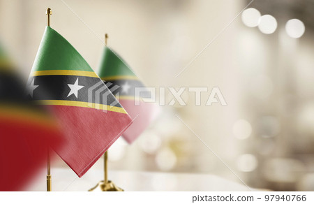 Small flags of the Saint Kitts and Nevis on an abstract blurry background 97940766
