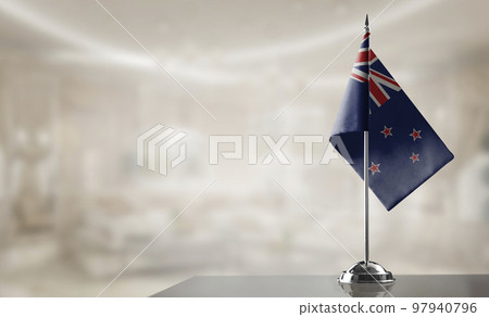 A small New Zealand flag on an abstract blurry background A small New Zealand flag on an abstract blurry background 97940796