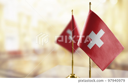 Small flags of the Switzerland on an abstract blurry background Small flags of the Switzerland on an abstract blurry background 97940979