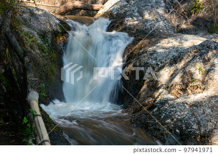 Mountain stream water flowing down over the rocks. 97941971