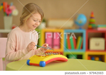 Beautiful girl playing musical instrument at home 97942083