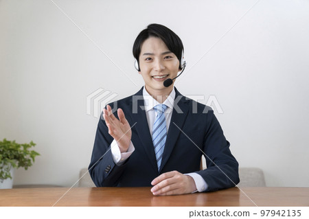 一個穿著西裝,戴著耳機,說話的年輕人 一個穿著西裝,戴著耳機,說話的年輕人 97942135