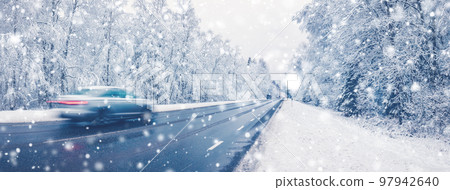 Cars on a road in snowfall rushing past on their own business. 97942640