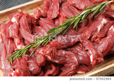 Raw sliced beef meat on wooden board Raw sliced beef meat on wooden board 97942964