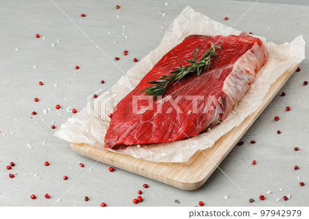 Raw beef fillet piece on wooden board close up Raw beef fillet piece on wooden board close up 97942979