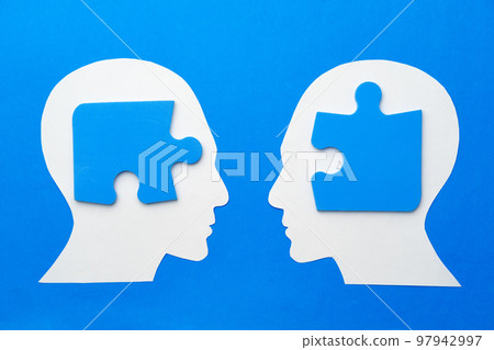Papercut head with jigsaw puzzle pieces on blue background 97942997