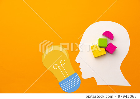 Papercut head silhouette with toy constructor pieces on yellow background 97943065