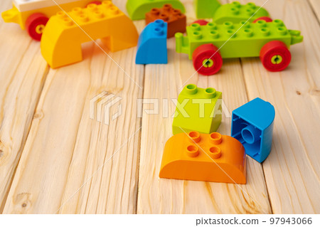 Toy constructor details on wooden background close up 97943066