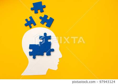 Papercut head silhouette with puzzle pieces on yellow background 97943124