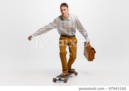 Going to work. Young man, student in retro style clothes surfing on skateboard to studying isolated over white background. 97943180