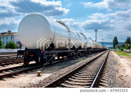 The train with tank cars stands on the tracks at the station. The train with tank cars stands on the tracks at the station. 97943355
