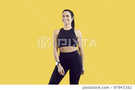 Portrait of beautiful happy successful female sports trainer isolated on yellow background. Portrait of beautiful happy successful female sports trainer isolated on yellow background. 97943382