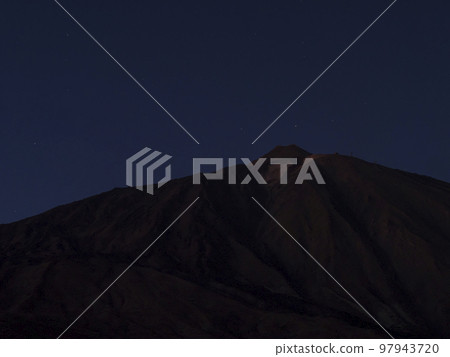 Long exposure night shot of the volcano Pico del Teide at Teide national park with stars on the blue sky. Tenerife Canary islands, Spain 97943720