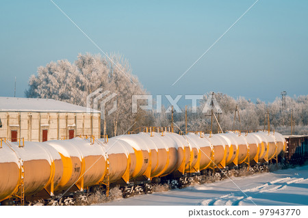 Snow covered tank-wagons with a crude oil standing on the railway 97943770