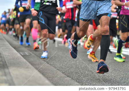 City marathon: the feet of a marathon runner running up a slope 97943791