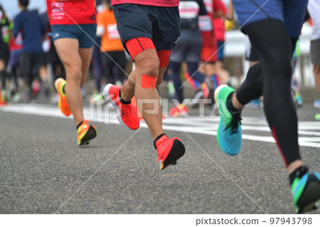 城市馬拉松：馬拉松運動員的腳跑上斜坡 97943798