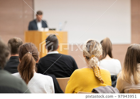 Speaker giving a talk in conference hall at business event. Rear view of unrecognizable people in audience at the conference hall. Business and entrepreneurship concept Speaker giving a talk in conference hall at business event. Rear view of unrecognizable people in audience at the conference hall. Business and entrepreneurship concept 97943951