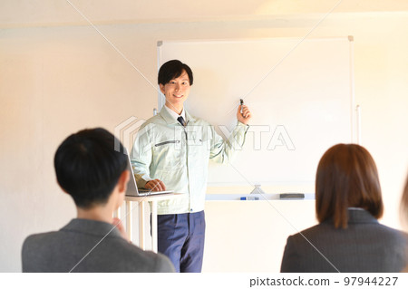A male worker giving a presentation and people taking the course A male worker giving a presentation and people taking the course 97944227