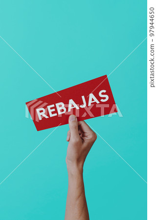 holds a sign with the text sale in spanish holds a sign with the text sale in spanish 97944650