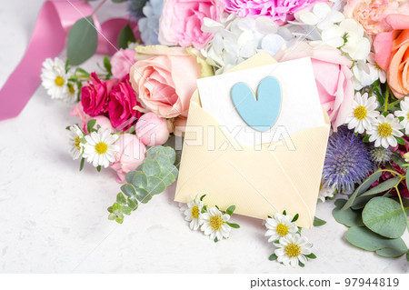Love letter, envelope with blue heart and card on flower bouquet background Love letter, envelope with blue heart and card on flower bouquet background 97944819