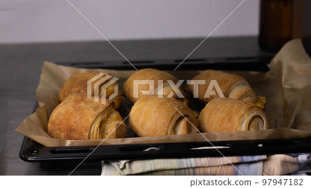 Homemade pastry puff buns with cheese on a baking sheet close-up Homemade pastry puff buns with cheese on a baking sheet close-up 97947182