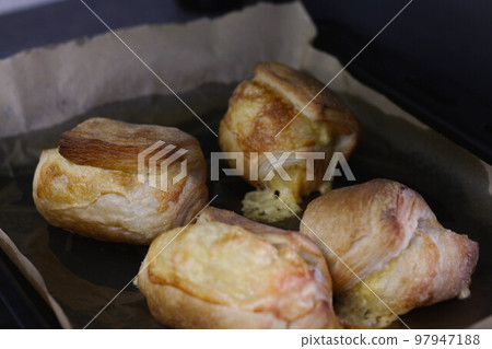 Homemade pastry puff buns with cheese on a baking sheet close-up 97947188