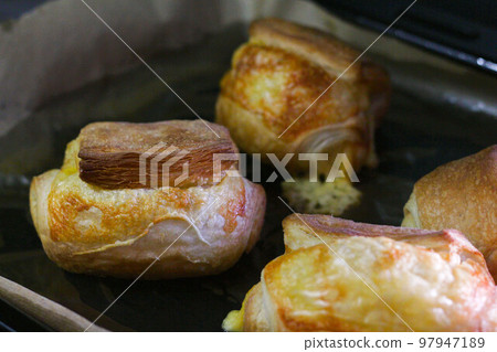 Homemade pastry puff buns with cheese on a baking sheet close-up 97947189