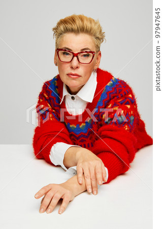 Extravagant, stylish and fashionable mature woman posing isolated over grey studio background. Fashion, style, beauty and emotions concept Extravagant, stylish and fashionable mature woman posing isolated over grey studio background. Fashion, style, beauty and emotions concept 97947645