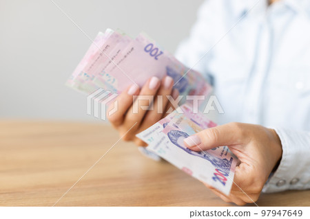 Woman propose Ukrainian 200 bill banknotes. Ukrainian money. 97947649