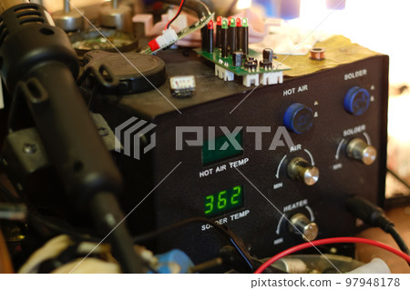 Defocus soldering Station. Soldering iron digital station on the workplace. Soldering station with LED display, heating control regulator, with hot air gun and soldering iron. Out of focus Defocus soldering Station. Soldering iron digital station on the workplace. Soldering station with LED display, heating control regulator, with hot air gun and soldering iron. Out of focus 97948178
