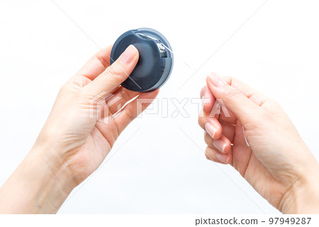 Hand holding dental floss (diagonal position) Hand holding dental floss (diagonal position) 97949287