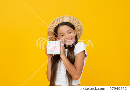 pleased teen child hold present box on yellow background 97949832