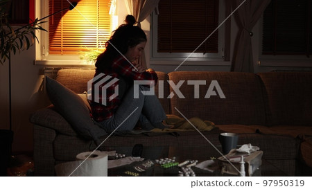 Psychology problem and panic. Lonely young Caucasian woman is sitting on sofa and swinging. Home evening. Obsessive-compulsive disorder and depression Psychology problem and panic. Lonely young Caucasian woman is sitting on sofa and swinging. Home evening. Obsessive-compulsive disorder and depression 97950319