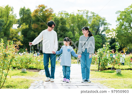 Family walking in the park together 97950903