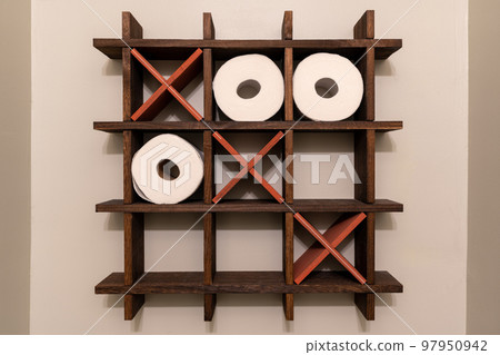 A Tic-Tac-Toe wooden shelf for rolls of toilet paper. Toilet decoration. Noughts and crosses, Xs and Os. A Tic-Tac-Toe wooden shelf for rolls of toilet paper. Toilet decoration. Noughts and crosses, Xs and Os. 97950942