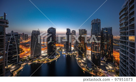 Tall residential buildings at JLT aerial night to day timelapse, part of the Dubai multi commodities centre mixed-use district. 97951073