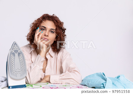 A girl worried about the next batch of shirts to be ironed. 97951558