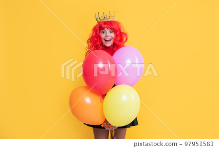 glad child in crown with party balloon on yellow background glad child in crown with party balloon on yellow background 97951581