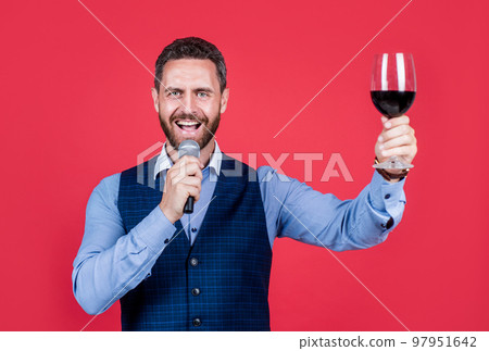 I demand the banquet continue. Toastmaster speak into microphone lifting glass of wine. Holding banquet. Ceremony or celebration. Public speaking. Oratory art. Skill in speech 97951642