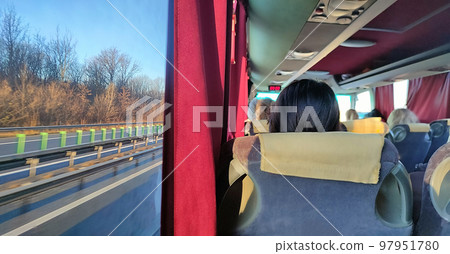 Group of tourist sitting in the bus and looking through the windows at forest Group of tourist sitting in the bus and looking through the windows at forest 97951780