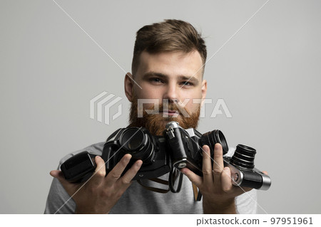 Close up portrait of man holding a old vintage film cameras. 97951961