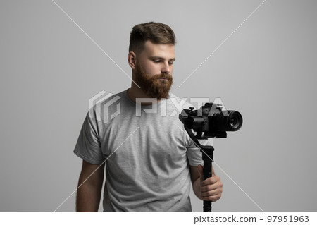 Professional cameraman with a camera gimbal. Filmmaking, videography, hobby and creativity concept. Professional cameraman with a camera gimbal. Filmmaking, videography, hobby and creativity concept. 97951963